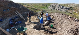 A group of people excavating at a rocky site